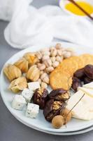 Cheese plate with crackers, dates and nuts photo