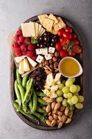 plato de queso con verduras y frutas frescas foto