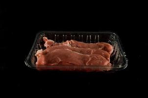 Packaged meat on dark background photo