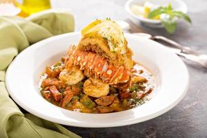 Grits with a lobster tail, shrimp and sausage photo