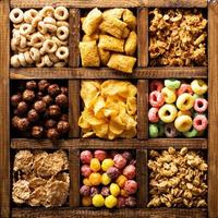 Variety of cold cereals in a wooden box overhead photo