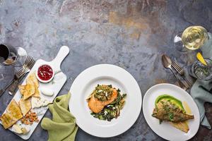 Big dinner table overhead view with steak and fish photo