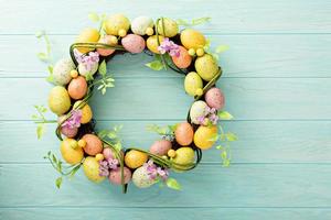 Easter eggs wreath on light blue background photo