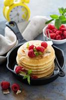 Stack of fluffy buttermilk pancakes with raspberry and coconut photo