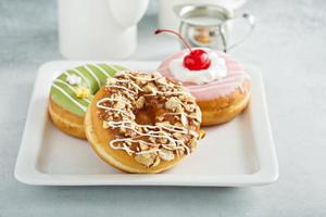 Assorted glazed fried donuts on a plate photo