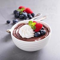 Chocolate pudding with whipped cream and berries photo