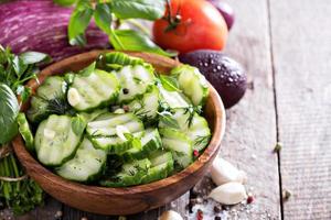 pepino en escabeche en un cuenco de madera rústica foto