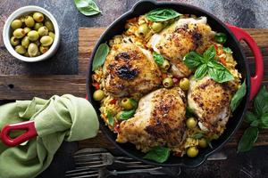 Roasted chicken thighs with rice and olives photo