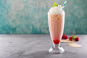 Iced milkshake with raspberry syrup and whipped cream photo