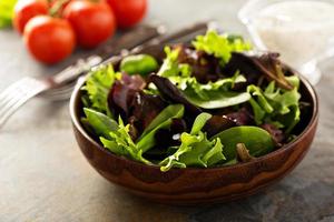 Fresh salad leaves in wooden bowl photo