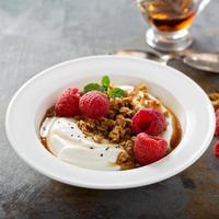 Yogurt bowl with raspberry and maple syrup photo