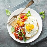 tostadas multicereales con huevo frito y tomates asados foto