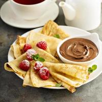 Crepes with raspberry and chocolate sauce photo