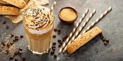 café con leche con caramelo helado en un vaso alto foto