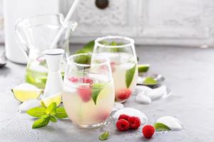 Cold summer cocktail with limes and raspberry photo