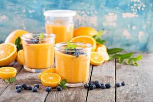 Orange and mango smoothie with granola photo
