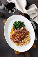 Grilled pork chop with cassoulet and braised greens photo