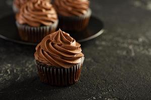 Dark chocolate cupcakes with ganache frosting photo