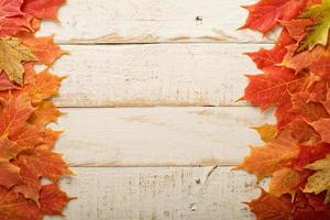 Fall leaves frame on whooden background photo