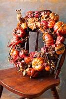 Festive autumn wreath with pumpkin and fall leaves photo