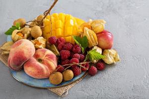 plato de frutas tropicales con mango y duraznos foto