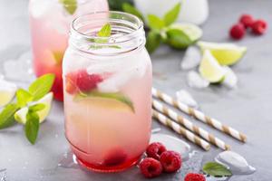 Cold green iced tea with lime and raspberry photo