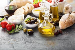 Olive oil in vintage bottles and italian cuisine ingredients photo