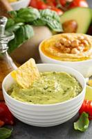 Guacamole and hummus in white bowls photo