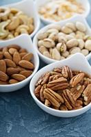 Variety of nuts in small bowls photo