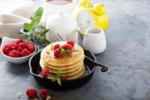 Stack of fluffy buttermilk pancakes with raspberry and coconut photo