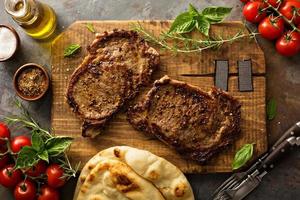 Grilled ribeye steaks on a wooden board photo