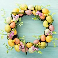 Easter eggs wreath on light blue background photo