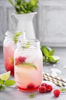Cold green iced tea with lime and raspberry photo