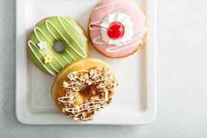 Assorted glazed fried donuts on a plate photo