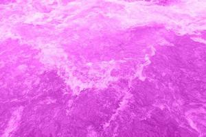 desenfoque borrosa textura de superficie de agua tranquila transparente de color púrpura con salpicaduras y burbujas. fondo de naturaleza abstracta de moda. ondas de agua a la luz del sol con espacio de copia. brillo de gota de agua rosa foto