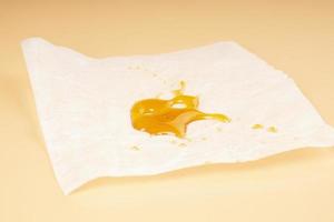 marijuana resin concentrate, amber cannabis wax in paper photo