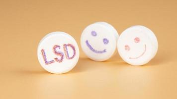 lsd pill closeup on beige background, psy tablet for trip photo