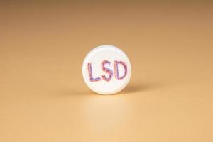 lsd pill closeup on beige background, psy tablet for trip photo