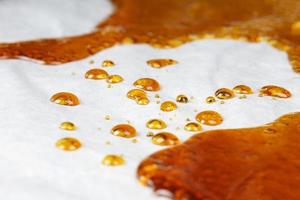 bho extract golden cannabis distillate wax for smoking vape in a glass container photo