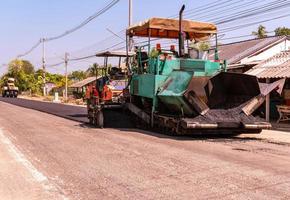 vista cercana de los trabajadores y las máquinas de asfaltado, trabajadores que hacen asfalto en la construcción de carreteras foto