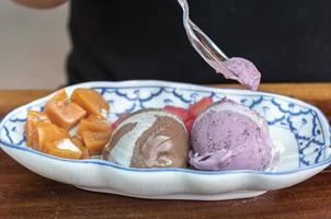 Various flavors of ice cream with toppings on the table photo