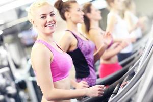 Group of women jogging on treadmill photo