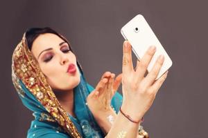 mujer árabe tomando selfie foto