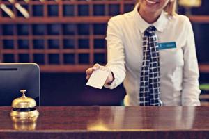 Pretty receptionist giving key card photo