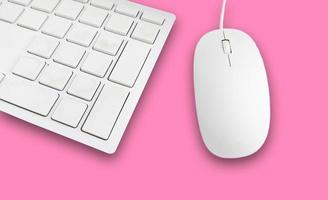 Keyboard and mouse on a pink background photo