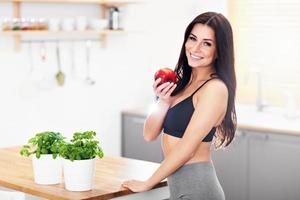 Colocar joven sonriente con manzana en la cocina moderna foto