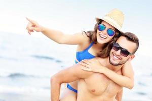 Young couple pointing at something at the beach photo