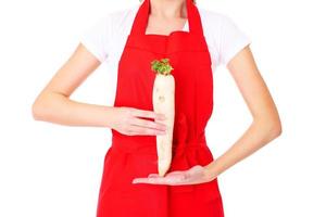 Woman with red apron holding an organic turnip photo