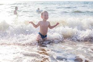 a little boy having fun in the sea on the waves photo
