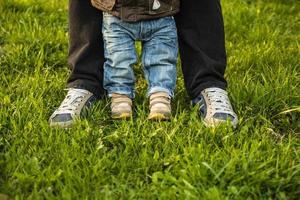 Two pairs of feet in the grass small and large photo